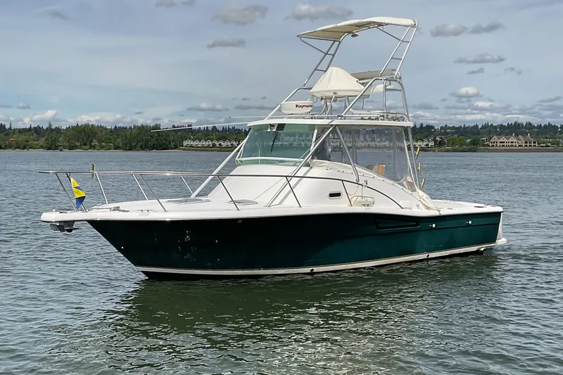 The Image of 1999 Pursuit Offshore Express boat on calm water with a clear sky background. - 0