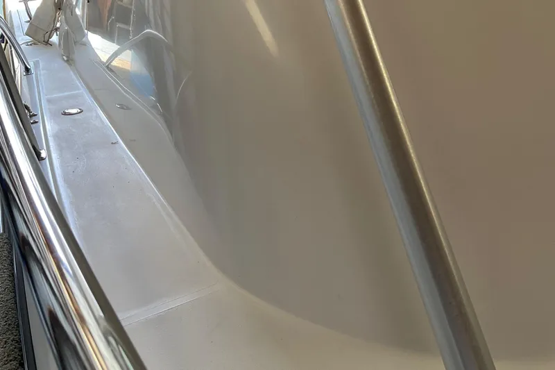 Slide: The Image of 1999 Pursuit OFFSHORE EXPRESS boat deck with sleek design and stainless steel railing. - 11