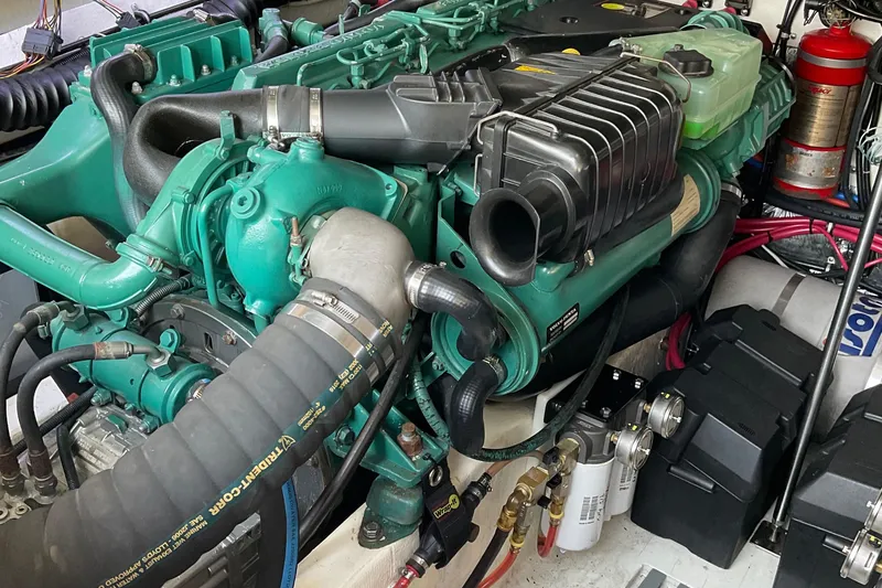 Slide: The Image of Engine of a 1999 Pursuit OFFSHORE EXPRESS boat, showcasing detailed components and wiring. - 13