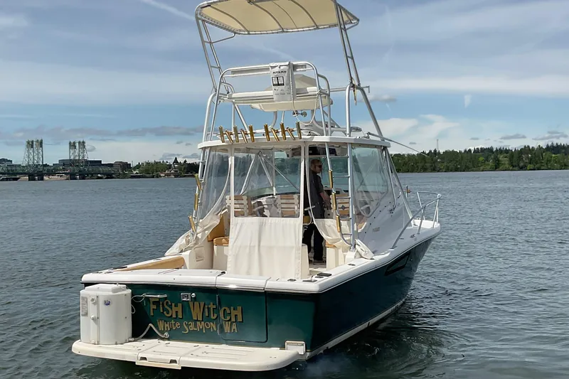 Slide: The Image of 1999 Pursuit OFFSHORE EXPRESS boat on water, featuring "Fish Witch" name, clear skies. - 3