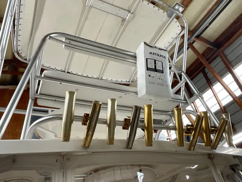 Slide: The Image of 1999 Pursuit Offshore Express boat with rod holders and electronics in a marina setting. - 32