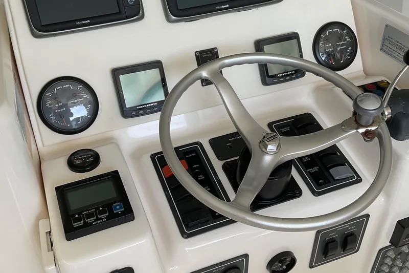 Slide: The Image of 1999 Pursuit Offshore Express boat dashboard with steering wheel and gauges. - 37