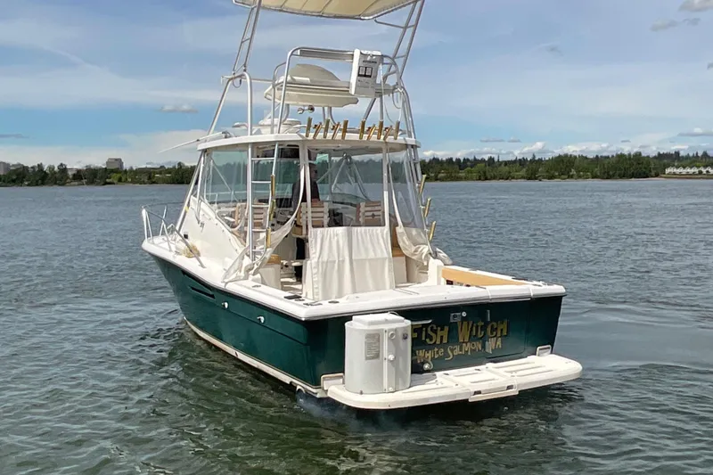 Slide: The Image of 1999 Pursuit Offshore Express boat on calm water, rear view, clear sky. - 4