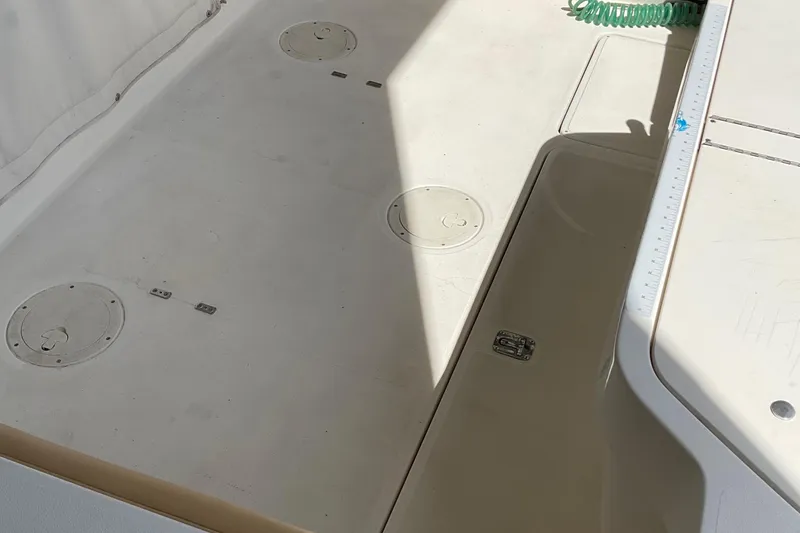 Slide: The Image of 1999 Pursuit OFFSHORE EXPRESS boat deck with storage compartments and hose. - 40