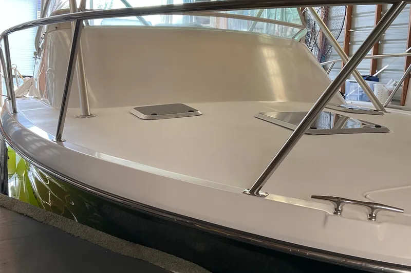 Slide: The Image of 1999 Pursuit Offshore Express boat with sleek deck and stainless steel railings. - 43