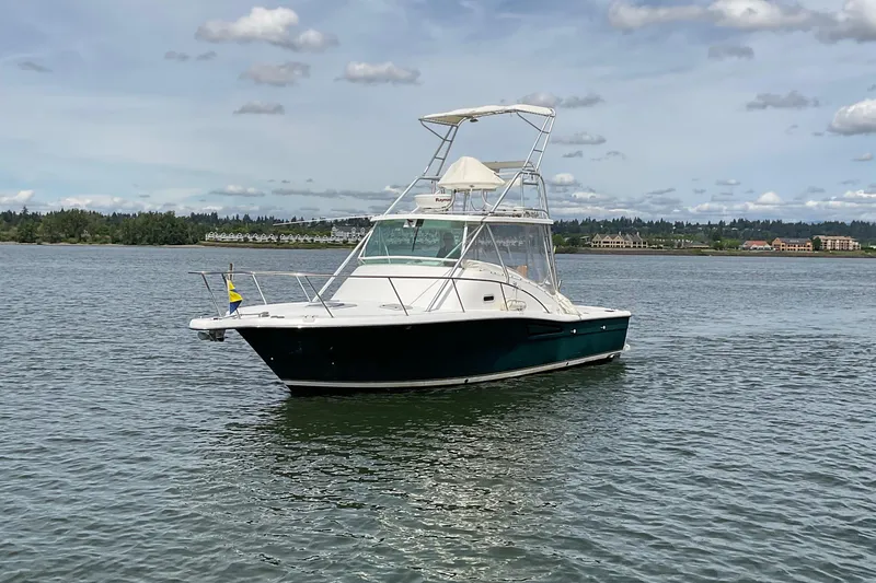 Slide: The Image of 1999 Pursuit Offshore Express boat on calm water under a cloudy sky. - 7