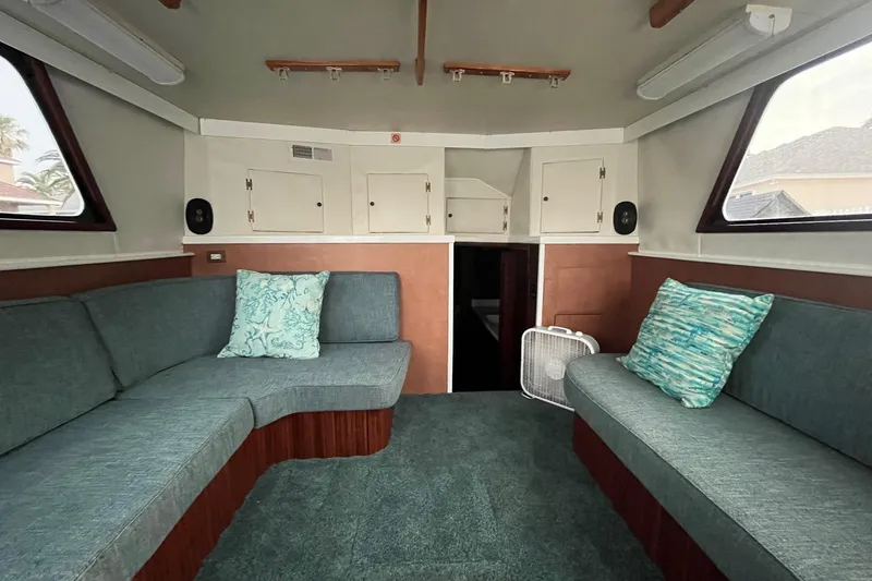Slide: The Image of Interior of 1972 Hatteras 42 Convertible boat with teal seating and decorative pillows. - 18