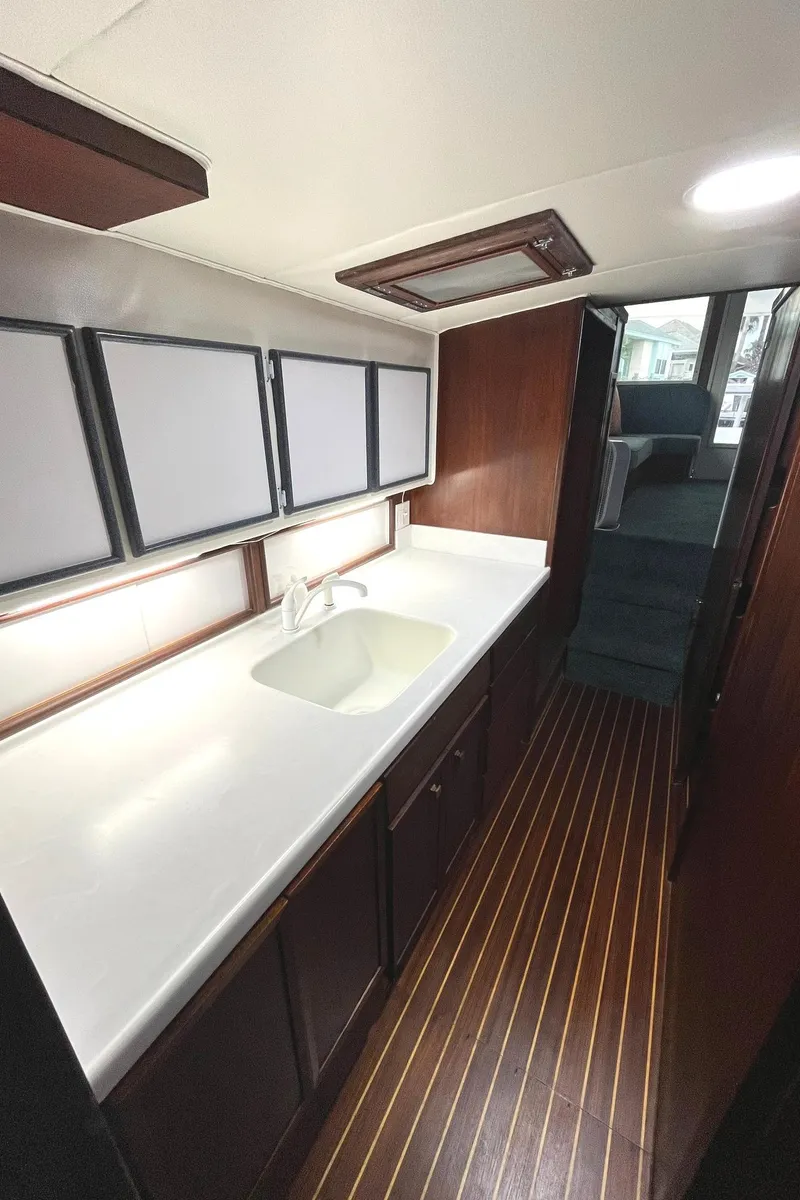 Slide: The Image of 1972 Hatteras 42 Convertible yacht interior with modern kitchen and wooden flooring. - 20
