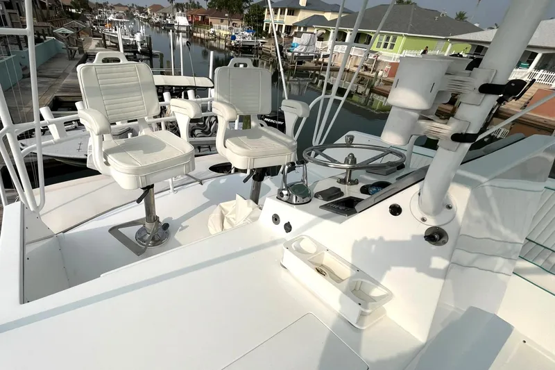 Slide: The Image of 1972 Hatteras 42 Convertible boat helm with white captain chairs and steering wheel. - 7