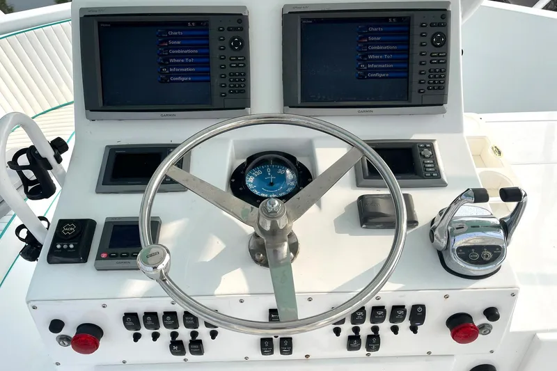 Slide: The Image of Control panel of a 1972 Hatteras 42 Convertible boat with dual screens and steering wheel. - 8