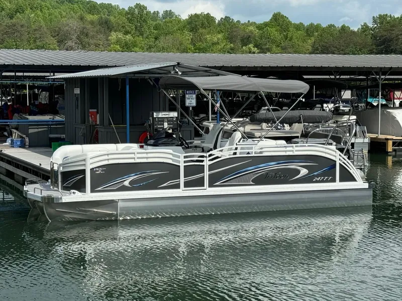 Slide: The Image of 2024 JC Spirit Super Sport 24TT DSL pontoon boat docked at marina. - 2