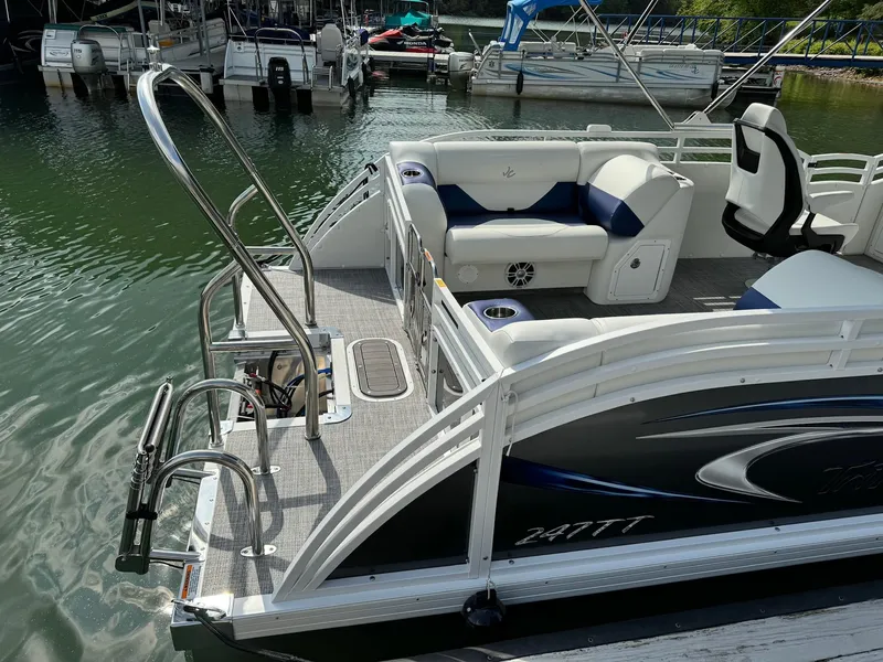 Slide: The Image of 2024 JC Spirit Super Sport 24TT DSL pontoon boat docked at marina. - 22