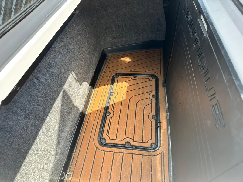 Slide: The Image of 2014 Nautique G25 storage compartment with wooden flooring. - 12