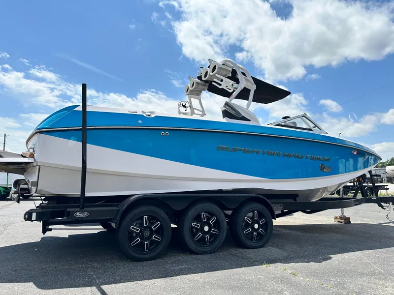 Slide: The Image of 2014 Nautique G25 boat on a trailer under a blue sky. - 3