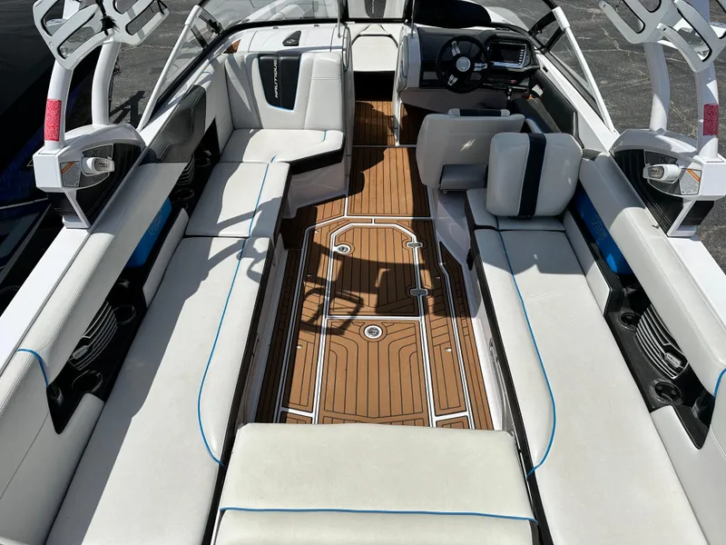 Slide: The Image of 2014 Nautique G25 boat interior with white seating and wooden flooring. - 4