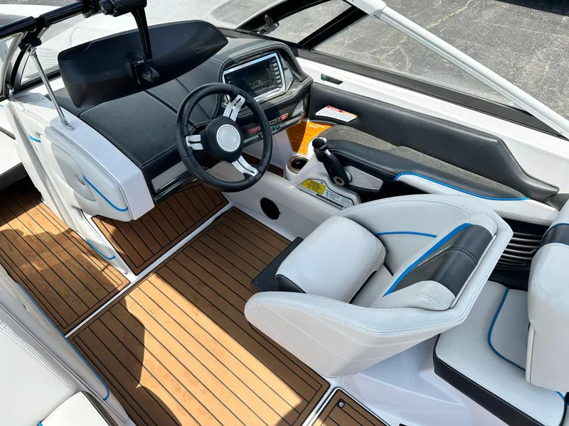 Slide: The Image of 2014 Nautique G25 boat interior with modern dashboard and teak flooring. - 5