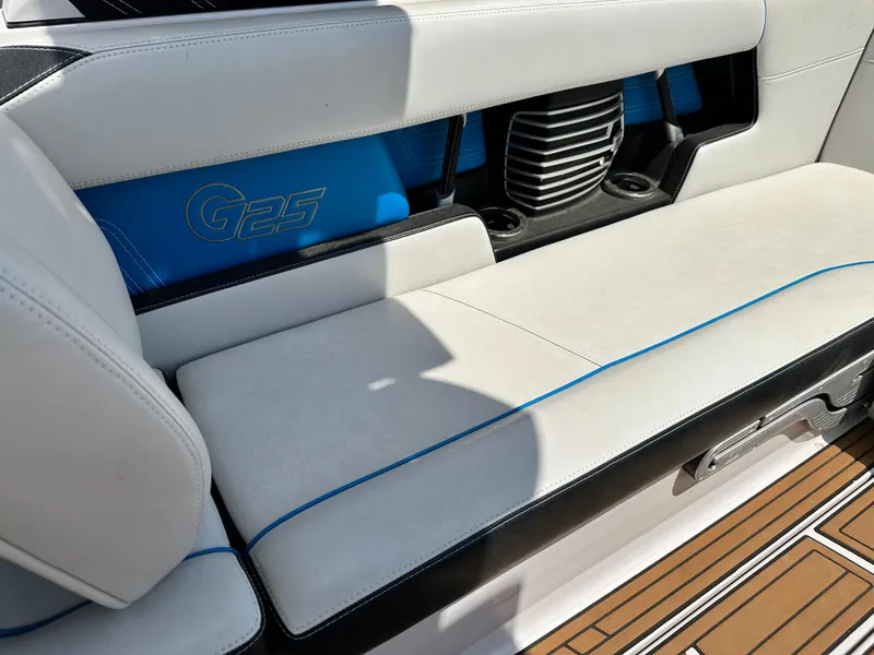 Slide: The Image of 2014 Nautique G25 boat interior seating with blue and white upholstery. - 7