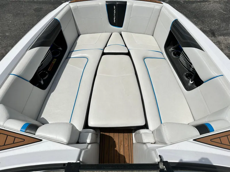 Slide: The Image of 2014 Nautique G25 boat interior with white and black cushioned seating. - 8