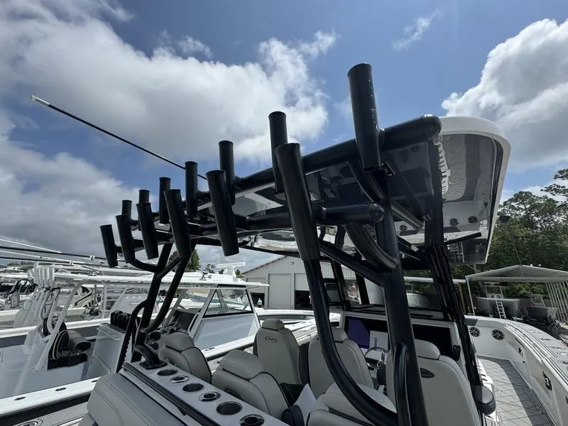 Slide: The Image of 2022 Invincible 46' Catamaran with rod holders and seating, docked under a partly cloudy sky. - 20