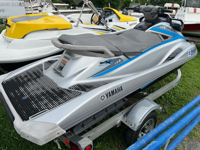 Slide: The Image of 2015 Yamaha WaveRunner VX Deluxe on trailer, silver and blue, parked on grass. - 2