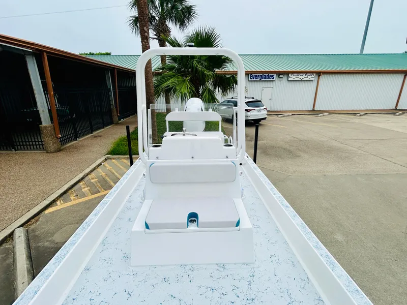 Slide: The Image of 2024 Shallow Sport 18 Sport boat, white interior, parked outdoors. - 16