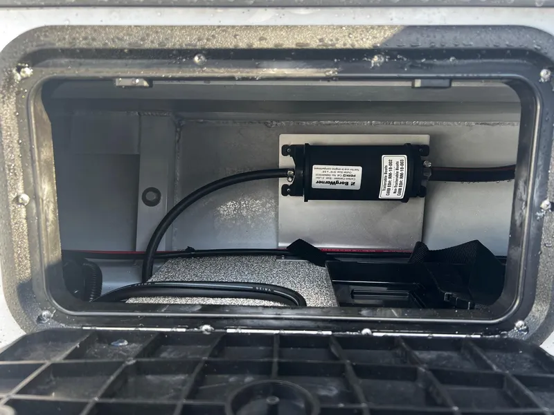 Slide: The Image of 2024 Fish Rite Angler 18 storage compartment with wiring and equipment. - 12