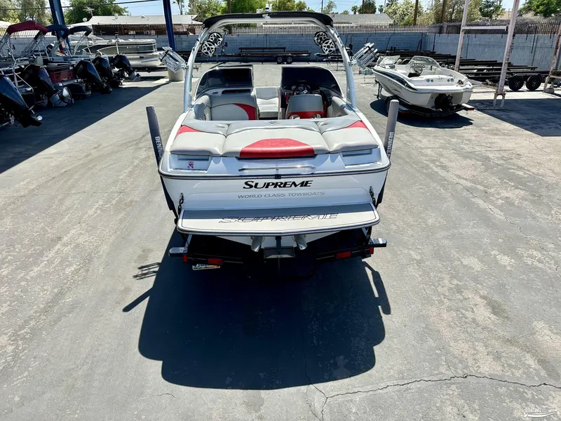 Slide: The Image of 2013 Supreme V226 boat in a marina, rear view, surrounded by other boats. - 1