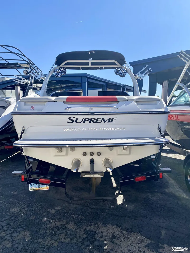 Slide: The Image of 2013 Supreme V226 towboat, rear view, parked outdoors under clear sky. - 3