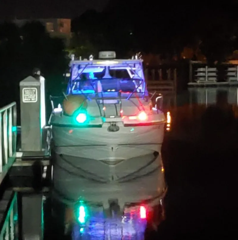 Slide: The Image of 2000 Boston Whaler 28 Conquest boat docked at night with navigation lights on. - 1
