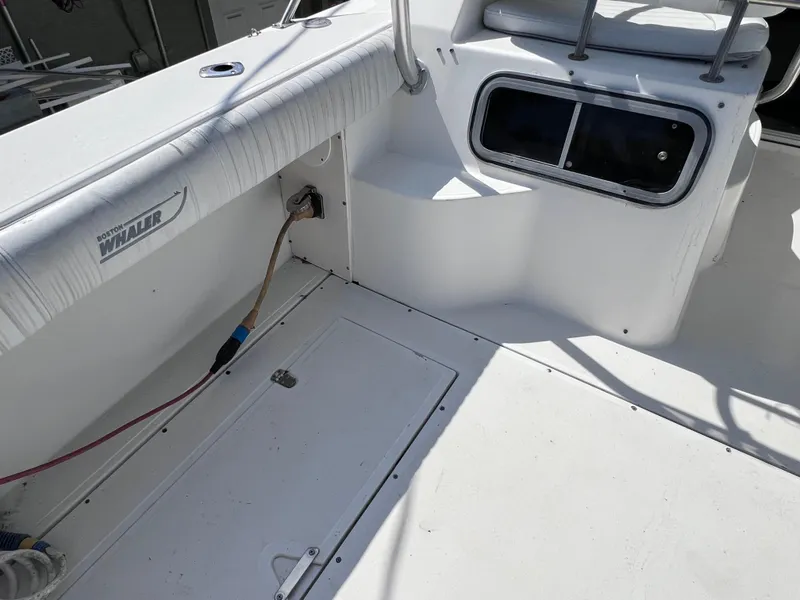 Slide: The Image of 2000 Boston Whaler 28 Conquest boat interior, white deck with seating and storage compartments. - 14