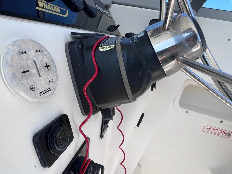 Slide: The Image of Boston Whaler 28 Conquest 2000 boat dashboard with Fusion audio controls and steering wheel. - 29