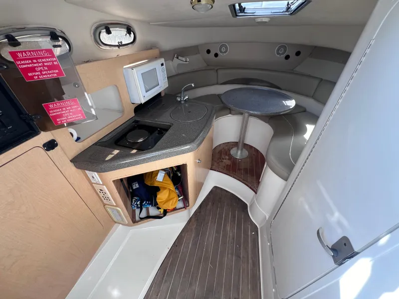 Slide: The Image of Interior of 2000 Boston Whaler 28 Conquest boat with kitchenette and seating area. - 32