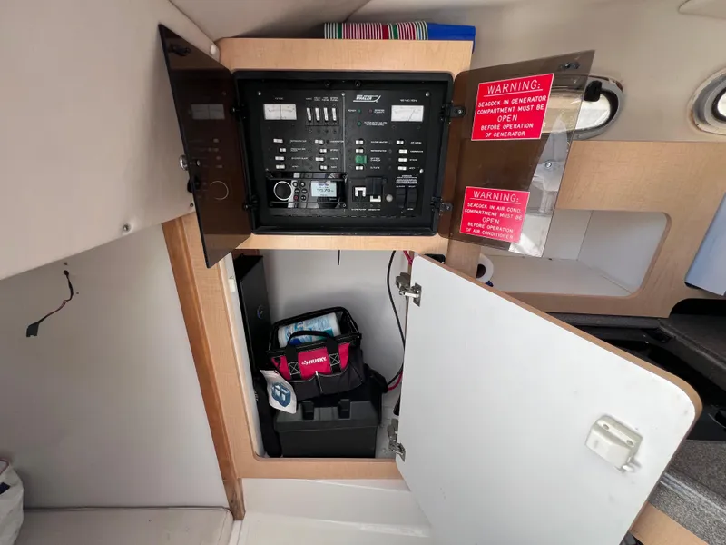 Slide: The Image of Electrical panel and storage area inside a 2000 Boston Whaler 28 Conquest boat. - 34