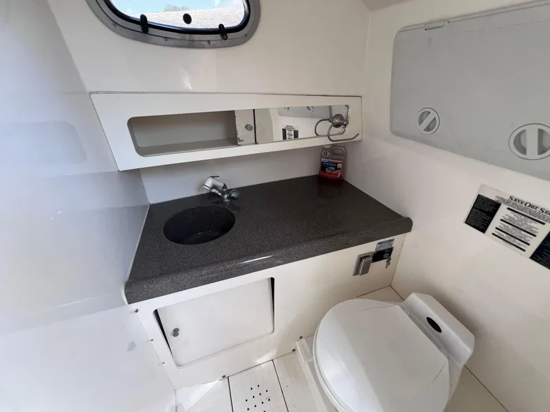 Slide: The Image of 2000 Boston Whaler 28 Conquest boat bathroom with sink, toilet, and storage. - 39