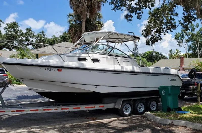 Slide: The Image of 2000 Boston Whaler 28 Conquest boat on a trailer in a residential area. - 4