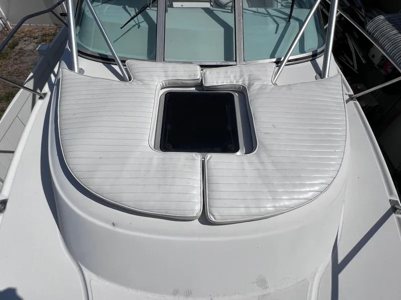Slide: The Image of 2000 Boston Whaler 28 Conquest boat deck with cushioned seating and hatch. - 42