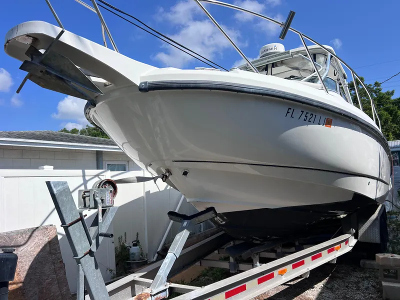 Slide: The Image of 2000 Boston Whaler 28 Conquest boat on a trailer in a residential area. - 5