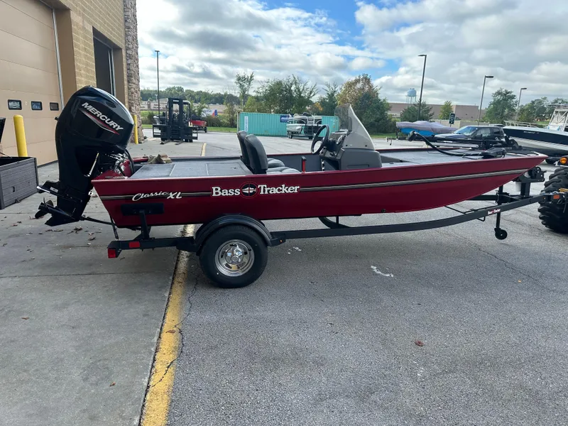 Slide: The Image of 2024 Tracker Bass Tracker Classic XL boat on trailer, parked outdoors. - 2