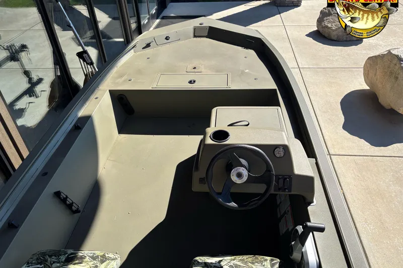 Slide: The Image of 2024 Tracker Grizzly 1754 SC boat interior with steering console and seating. - 4