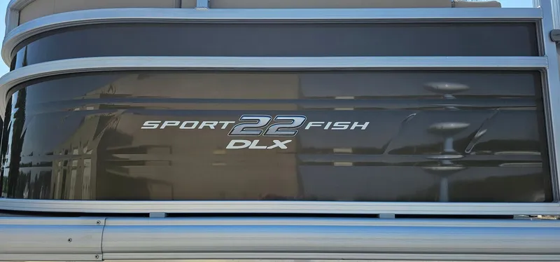 Slide: The Image of 2024 Sun Tracker SportFish 22 DLX pontoon boat side view. - 2