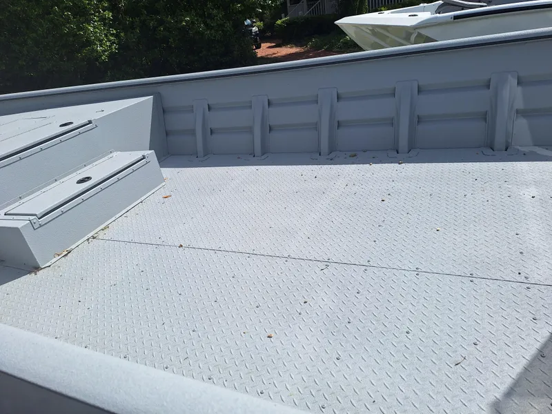 Slide: The Image of 2024 SeaArk 2472 CUB boat interior with diamond plate flooring and storage compartments. - 7