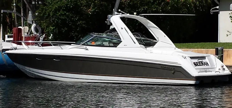 The Image of 2004 Formula 330 SS boat docked on a calm waterway. - 0