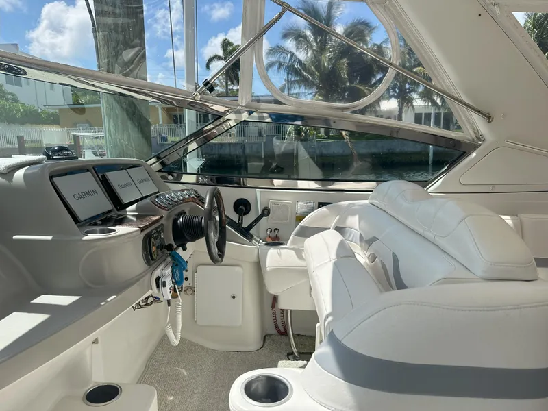 Slide: The Image of 2004 Formula 330 SS boat cockpit with white seating and modern controls. - 18