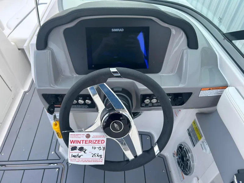 Slide: The Image of 2024 Chaparral 21 Surf boat dashboard with steering wheel and Simrad display. - 11