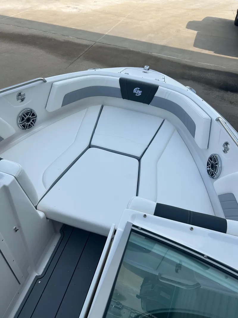 Slide: The Image of 2024 Chaparral 21 Surf boat interior with white and gray seating. - 13