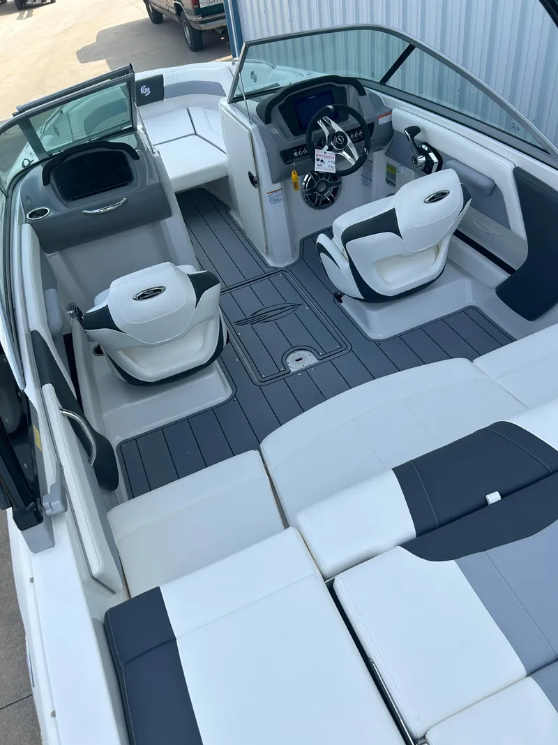 Slide: The Image of 2024 Chaparral 21 Surf boat interior with white and gray seating and modern dashboard. - 9
