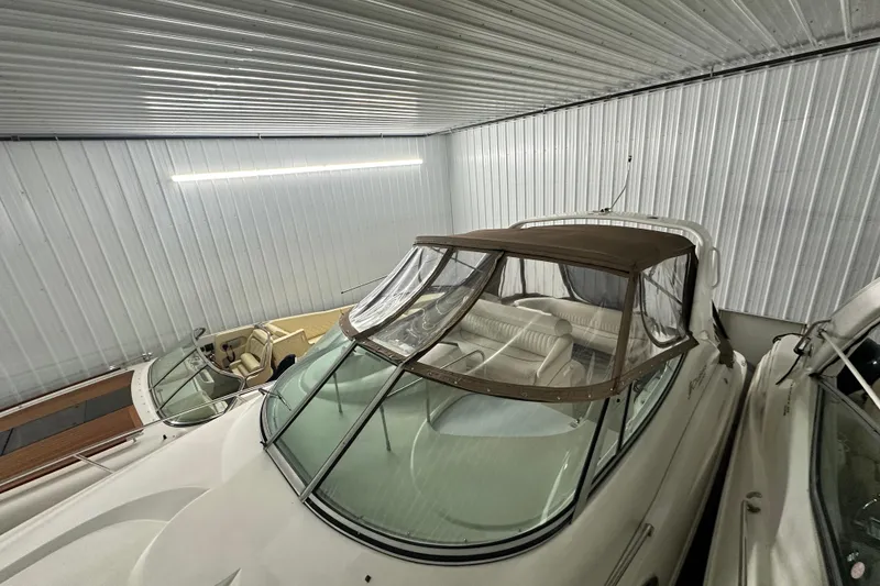 Slide: The Image of 1998 Cruisers Yachts 3075 Rogue in storage, featuring a covered cockpit and sleek design. - 14