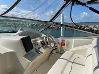 Slide: The Image of 1998 Cruisers Yachts 3075 Rogue cockpit with steering wheel, dashboard, and water view. - 3