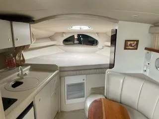 Slide: The Image of 1998 Cruisers Yachts 3075 Rogue interior with white seating, wooden table, and modern amenities. - 7