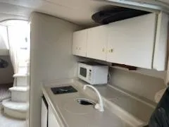 Slide: The Image of Interior of 1998 Cruisers Yachts 3075 Rogue, featuring kitchenette and cozy seating area. - 8